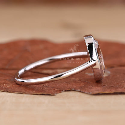  A bezel set diamond ring with a cushion rose cut diamond, shining beautifully in natural light.