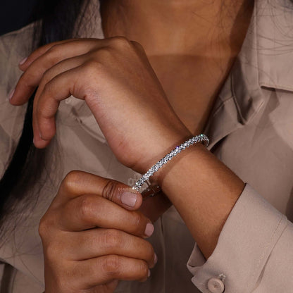 Round diamond bangle bracelet displayed on a jewelry stand